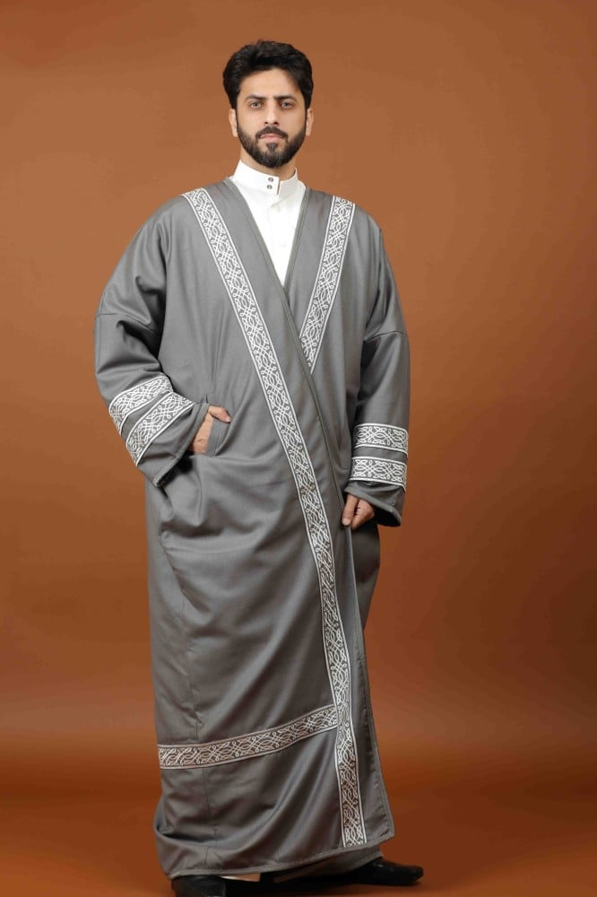 رجل يرتدي بشتاً رجالياً شتوياً بتصميم الفروة بلون رمادي فضي وتطريز أبيض على الصدر والأكمام