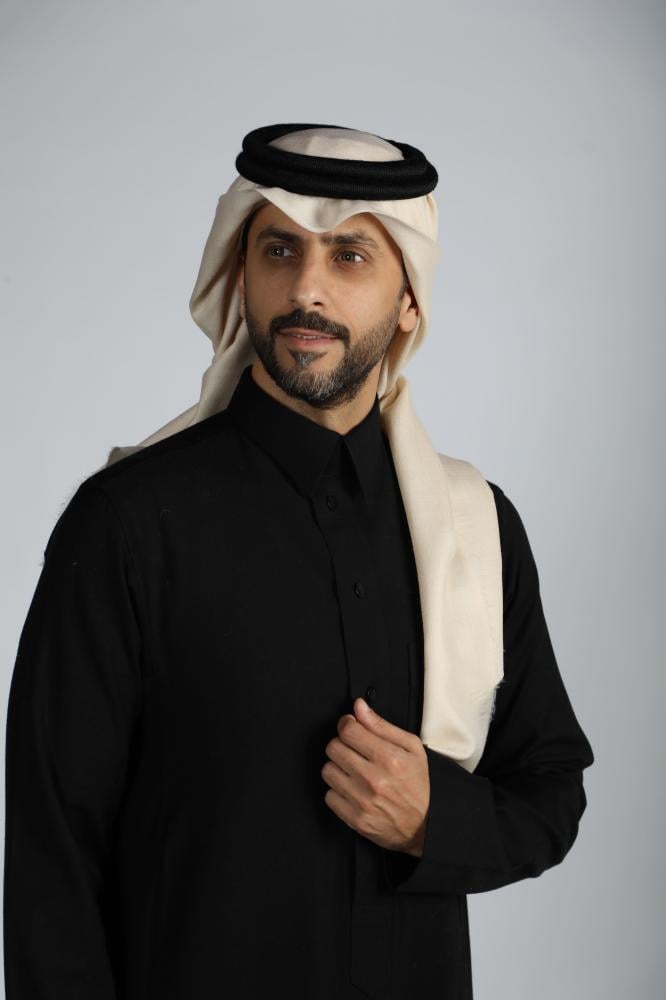 رجل يرتدي غترة كشميري سكرية سادة مع ثوب أسود وعقال