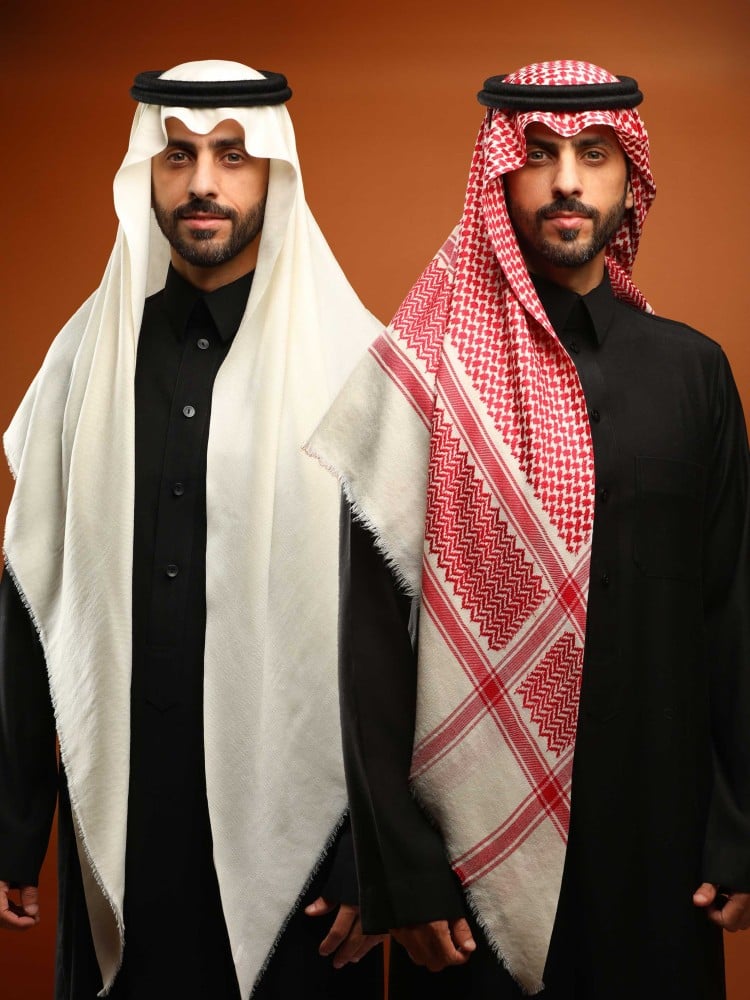 رجلان يرتديان غترة كشميري بيضاء وشماغ كشميري أحمر مع ثوب أسود