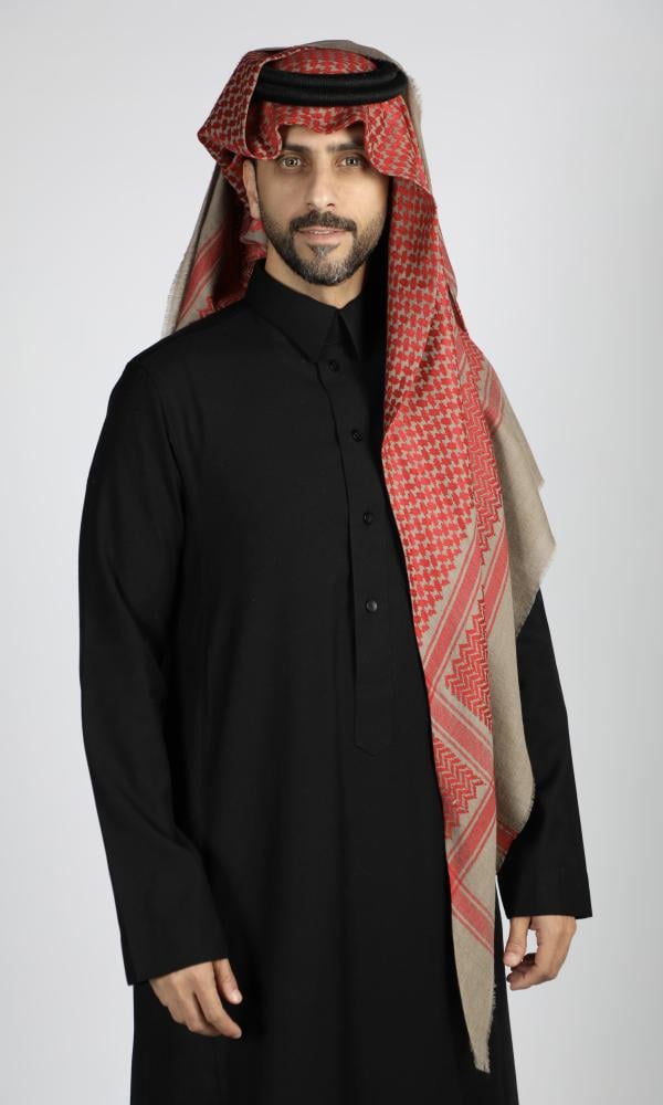 رجل يرتدي شماغاً كشميرياً شتوياً بنقش أحمر على أرضية بيج غامقة مع ثوب أسود (3 من 4)
