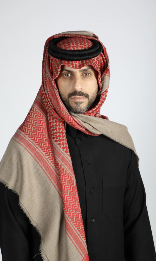 رجل يرتدي شماغاً كشميرياً شتوياً بنقش أحمر على أرضية بيج غامقة مع ثوب أسود (4 من 4)